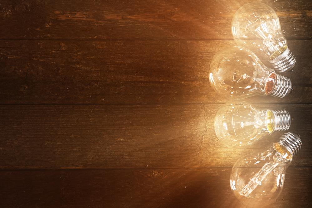 Glowing lightbulbs on wooden background